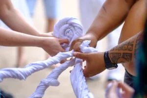 Participants réalisant un travail manuel de tressage pendant un atelier d’artisanat traditionnel au Tiki Village à Moorea