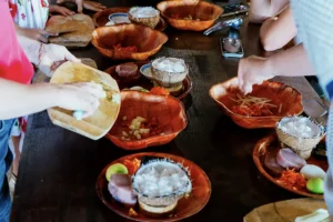 Lunch table with Tahitian dishes served in traditional bowls at Tiki Village in Moorea