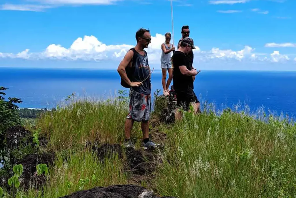 Des personnes se trouvent au sommet du mont de Temae surplombant l'océan
