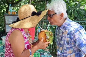 Couple partageant une noix de coco fraîche avec deux pailles pendant une pause dégustation à Moorea