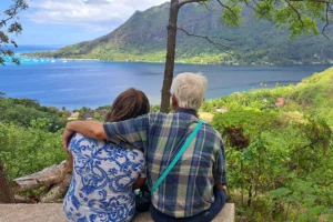 Couple seen from behind admiring Moorea’s lagoon and Mount Rotui from the Magic Mountain trail