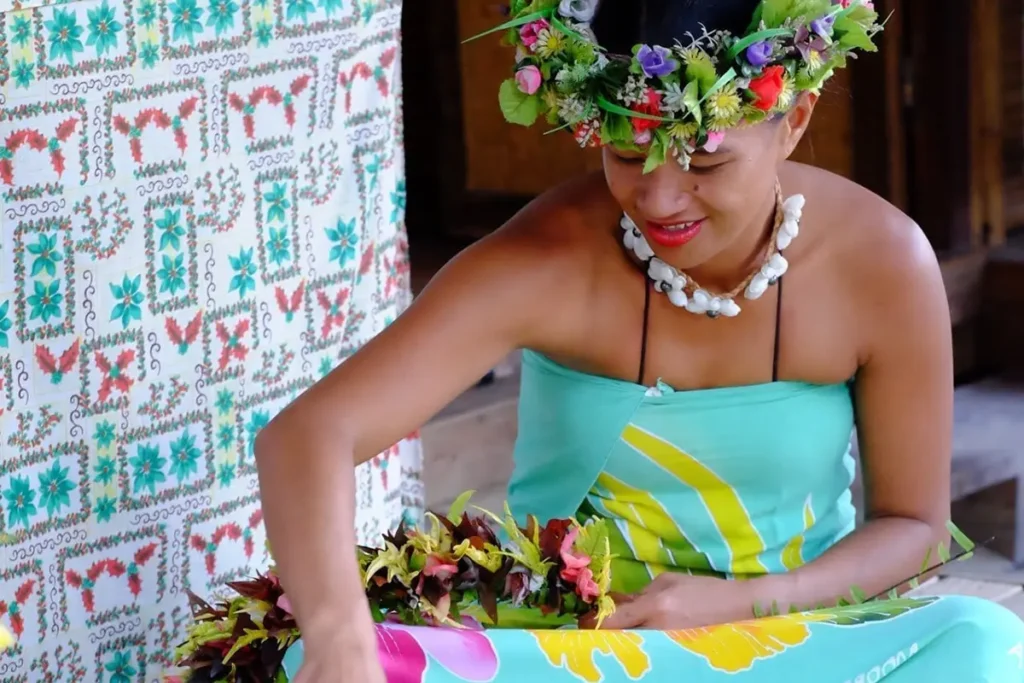Une jeune femme tahitienne réalise une couronne de fleurs lors d'un atelier culturel à Moorea