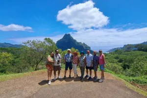 Group of eight cruise guests at Opunohu Belvedere in front of Mount Rotui during a private Moorea excursion