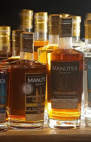 Des bouteilles de rhum Manutea Tahiti posées sur une étagère de la salle dégustation privée dans l'usine Rotui à Moorea