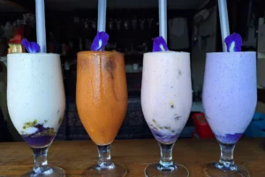 Quatre smoothies frais de différentes couleurs servis au Fare Faa Roa près de la Montagne Magique à Moorea