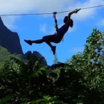 Une personne s'amuse sur une tyrolienne du parc aventure et accrobranche du Tiki Parc à Moorea