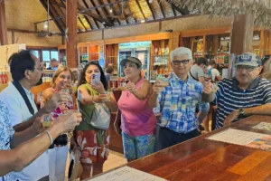 Groupe de visiteurs levant leurs verres pendant une dégustation gratuite au magasin d’usine Rotui Manutea à Moorea