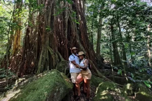 Couple beside a large banyan tree during a private guided hike to 3 Pinus in Moorea
