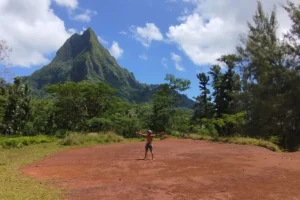 Hiker standing on Bounty Plateau with Moorea’s volcanic peaks in the background