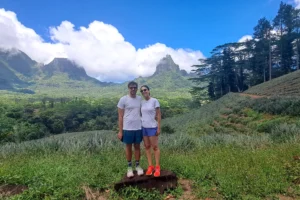 Couple standing on a rock among pineapple fields with the mountains of Opunohu in the background