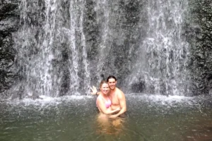 Couple profitant de l’eau au pied de la cascade de la Vaioro pendant une excursion privée à Moorea