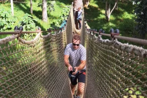 Participant avançant dans un grand filet suspendu du parcours aventure Tiki Parc à Moorea