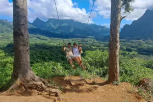 Couple on the Three Pinus swing facing the mountains of Opunohu Valley in Moorea