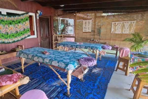 Tables de massage installées dans un espace couvert décoré de paréos polynésiens à Moorea