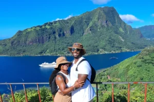 Couple at the Magic Mountain viewpoint with Mount Rotui, the bay and a cruise ship in the background