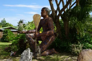 Grande sculpture tiki en bois tenant un ananas à Pineapple Beach sur l’île de Moorea