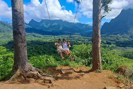 A hiking couple enjoying a swing during a guided hike to the 3 Pinus Pass in Moorea.