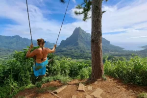 Hiker on the 3 Pinus swing facing Moorea’s mountain panorama