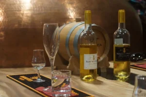 Bouteilles de rhum et vin Manutea posées devant un fût en bois dans l’usine Rotui à Moorea
