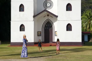 Family in front of Sainte-Famille Church in Haapiti during a private Moorea tour