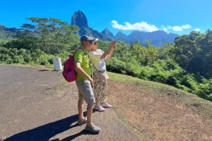 Visitors photographing a volcanic peak in Moorea from Opunohu Belvedere lookout