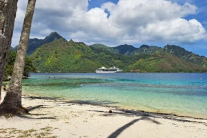 Plage Mareto Ta’ahiamanu avec cocotiers, montagnes et bateau de croisière dans la baie de Moorea