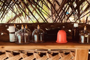 Petites cloches et accessoires de soin alignés sur une étagère en bambou dans l’espace massage à Moorea