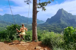 Woman on the 3 Pinus swing facing the mountains of Opunohu Valley in Moorea