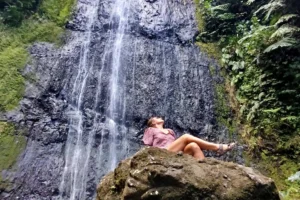 Femme devant la cascade de la Vaioro à Afareaitu pendant une randonnée guidée privée à Moorea