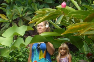 Femme et enfant au milieu des grandes plantes tropicales pendant une visite du Moorea Tropical Garden