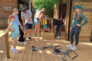 Famille recevant les consignes de sécurité et les baudriers avant le parcours aventure du Tiki Parc à Moorea