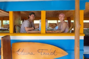 Couple seated inside Truck Uaina O2 Coco, a former Tahitian truck converted into a restaurant in Moorea