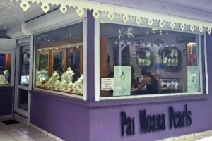 Façade violette de la boutique Pai Moana Pearls avec vitrines de bijoux au Petit Village à Moorea