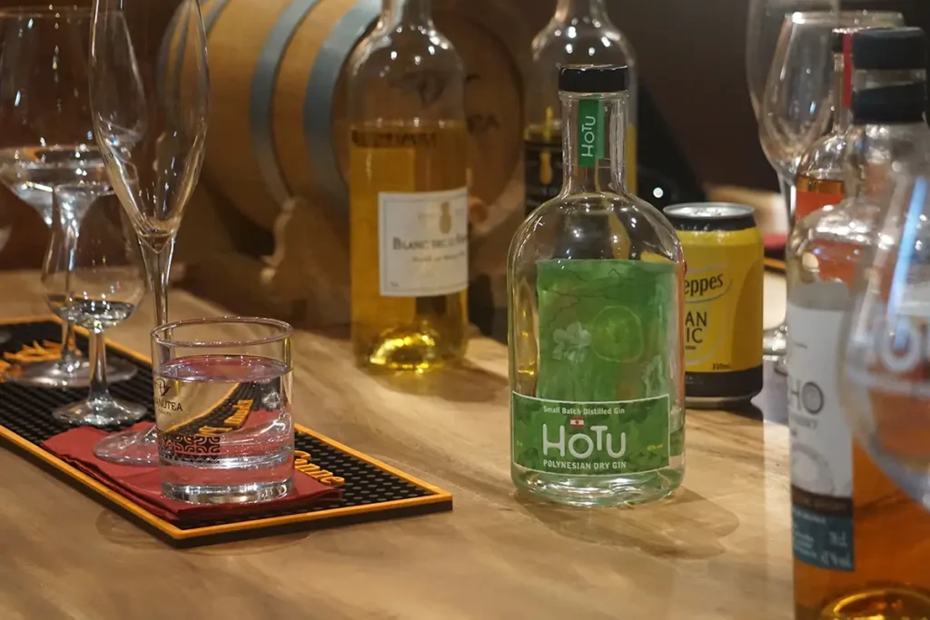 Des bouteilles de rhum, gyn et blanc d'ananas sont posées sur une table en bois dans la salle de dégustation privée de l'usine Rotui de Moorea