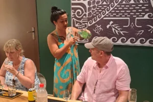 Guide expliquant les cuvées à des visiteurs pendant une dégustation privée dans le salon Rotui Manutea