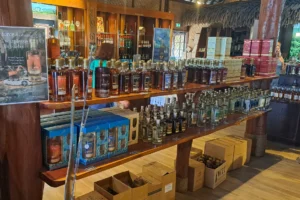 Étagères remplies de bouteilles de rhum, vins et produits Rotui Manutea dans la boutique de l’usine à Moorea