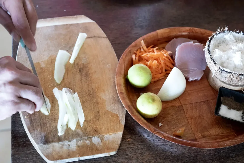 Une personne prépare un plat tahitien à base d'oignon et de noix de coco