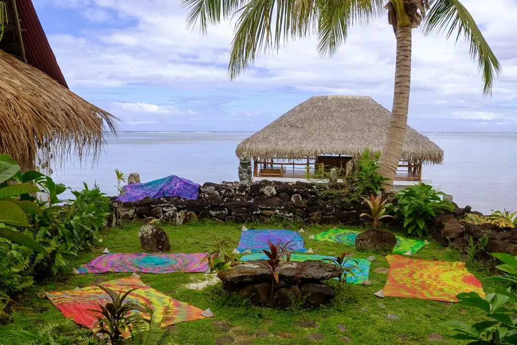 Des paréos colorés sont étalés sur l'herbe devant le lagon de Moorea pour le séchage de la teinture de paréo après leur fabrication