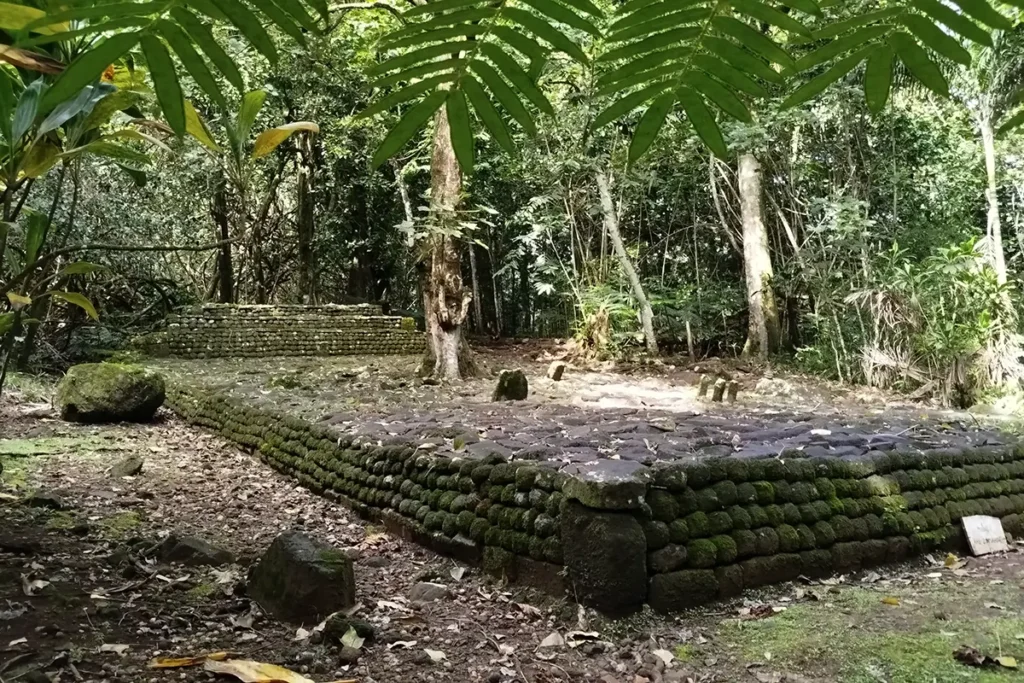Un Marae Polynésie fait de pierre rondes volcanique. Une nature tropicale l'entoure