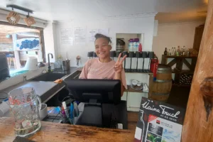Smiling Tahitian waitress behind the counter at Truck Uaina O2 Coco in Moorea