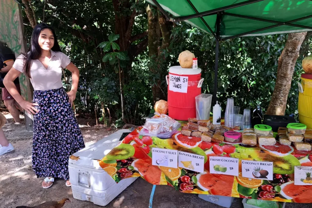Une jeune femme tahitienne vends des gâteaux locaux et des jus de fruits sur le site du Belvédère à Moorea