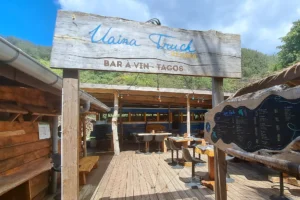 Uaina Truck sign and restaurant entrance with a wooden terrace in Moorea