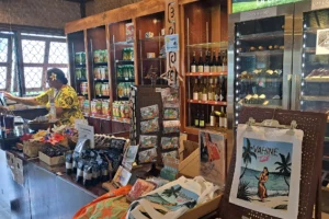 Visiteuse dans la boutique Rotui Manutea entourée de boissons, souvenirs et produits locaux de Moorea