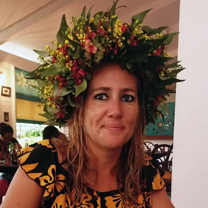 Une jeune femme portant une couronne de fleurs tahitienne et une robe orange et noire